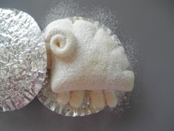 В голову поместите кусочек шоколада (глазик), затем прикройте голову и присыпьте тело мукой, используя ситечко