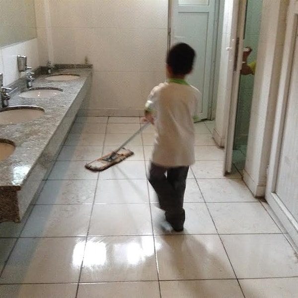 Fotoğrafta okulun tuvaletinde ilkokul öğrencisi bir erkek çocuğunun yerleri temizlediği görülüyor...