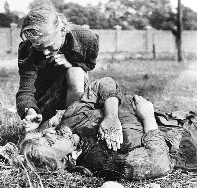 8. Eylül 1939, Polonya. Patates toplamak için çıktığı tarlada SS birliklerinin makineli tüfek saldırısı sonucu hayatını kaybeden küçük kız ve başında ağlayan 10 yaşındaki ablası.