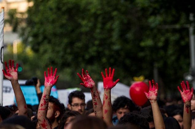 Santiago'da bazı kadınlar ellerini kırmızıya boyayarak yürüyüşe katıldılar.