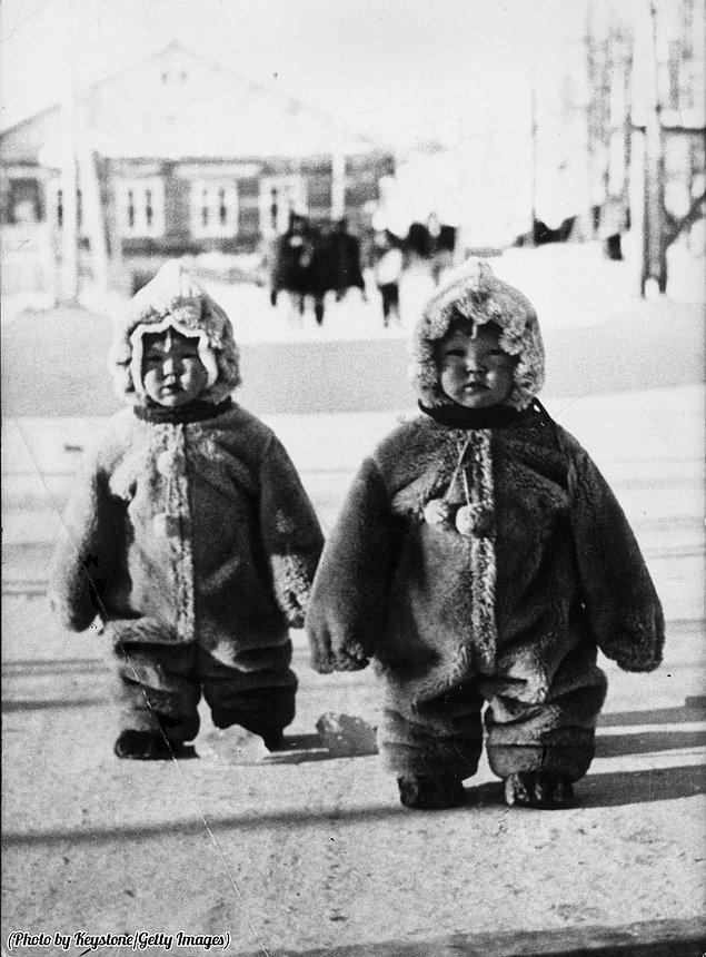 20. Yeni yeni yürümeye başlayan, soğuktan korunmaları için kat kat giydirilmiş kıyafetleriyle tıpkı penguenleri andıran ikizler, Rusya, 1968.