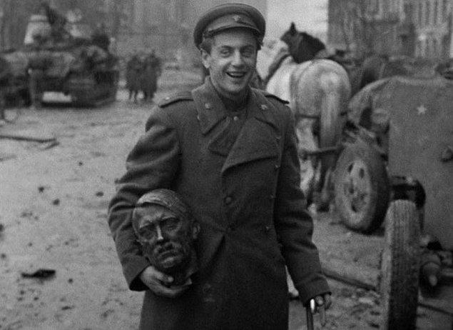 23. Berlin sokaklarında Hitler heykelinin kafasını müthiş bir keyifle taşıyan bir Sovyet askeri, 1945.