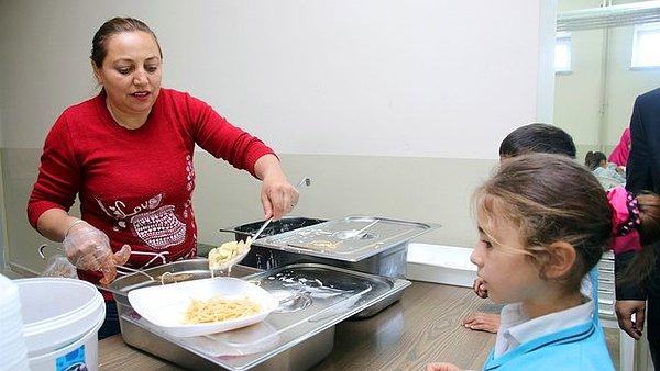 Bir çocuğunun okuduğu Sefil Selimi Ortaokulu'nda da taşımalı eğitim gören çocuklara yemek dağıtımına yardımcı oluyor.