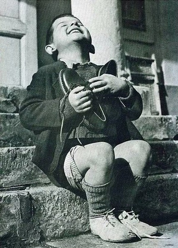 19. Шестилетний мальчик из приюта получил в подарок от Красного Креста новые ботинки, 1946 год.