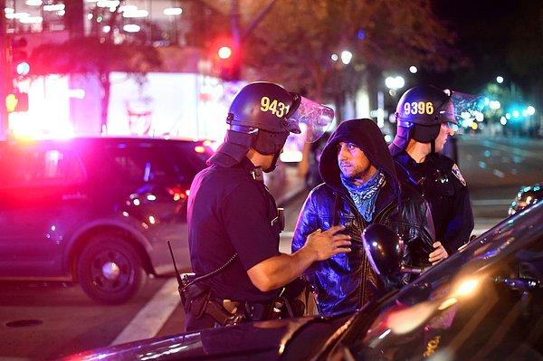 Polis, Kaliforniya'da seçim sonuçlarını protesto eden bir göstericiyi göz altına alıyor.