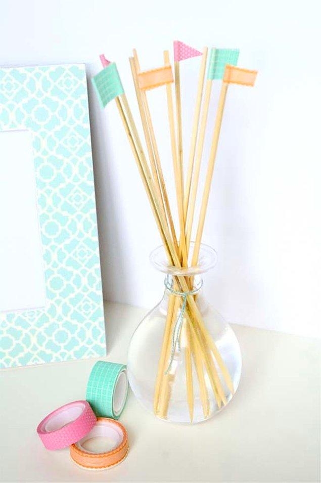 1. Bambu çubuklarını renkli bantlar ile süsleyin.