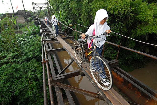 19. Индонезийские дети ходят в школу по навесному мосту, соединяющему деревни Суро и Племпунган в Бойолали, Центральная Ява, Индонезия