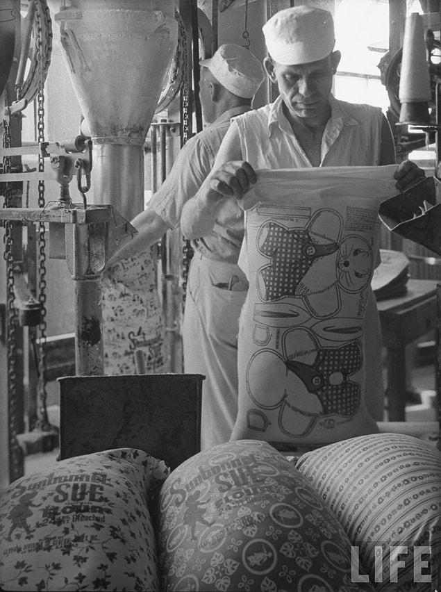 26. A worker for the Sunbonnet Sue Flour company prepares one of the pattern bags to be loaded with flour.  1939.
