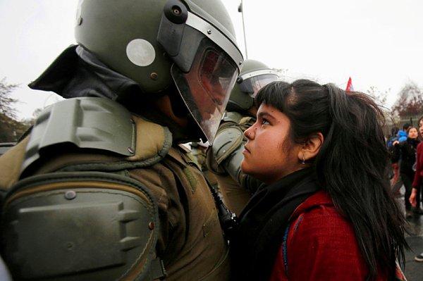 1. Şili'de 1973 yılında yapılan askeri darbenin hatırlanması için yapılan protestoda bu genç kız çevik kuvvetin gözlerinin içine korkusuzca bakıyor.