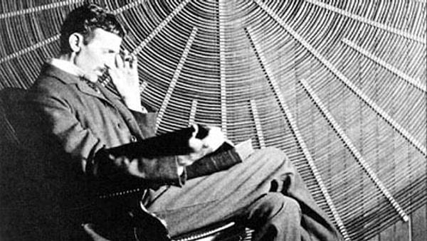 8. Tesla yüksek gerilim trafosunun sarmal bobininin önünde oturup kitap okurken.