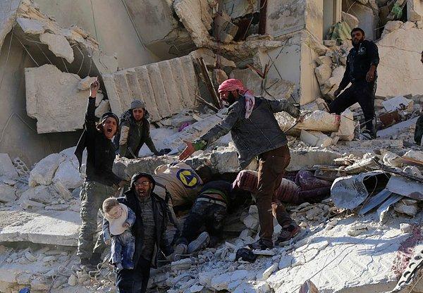 1. Sukkari bölgesinde Suriye hükümeti güçleri tarafından gerçekleştirilen hava saldırıları sonrasında siviller ve kurtarma ekipleri bir bebeği kurtarıyor ve enkazda kalmış diğer yaralıları arıyor.