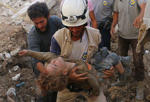21. Beyaz Baretliler gönüllüsü Karm Homad'da Esad güçlerinin saldırısının sebep olduğu enkazdan bir kız çocuğunun bedenini çıkarıyor.
