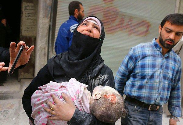28. Halep'in al-Muasalat bölgesinde hava saldırıları sonrasında bir enkazdan çıkarılan bebeğinin cesedini taşıyan bir kadın.