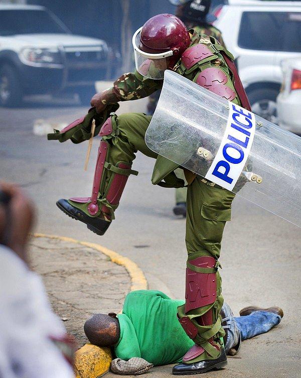 35. Kenya'nın başkenti Nairobi'de seçimleri ve yozlaşmayı protesto eden gruba polis müdahele etti. Kenya polisinin bir göstericinin kafasına bastığı bir fotoğraf.