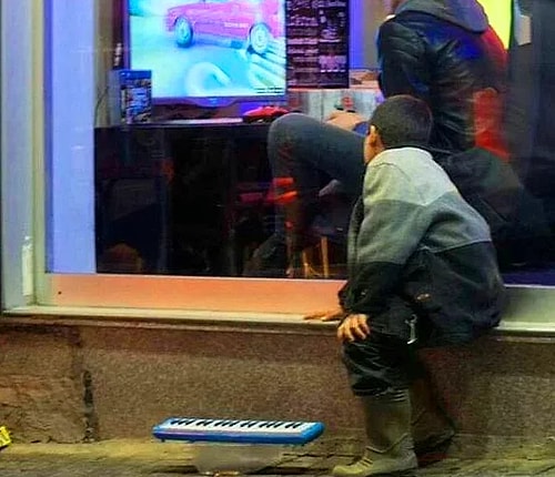 Sokakta çalışmak zorunda olan ama içeride oyun oynayanları görünce tüm dikkati oraya yapışıp kalan bu küçük çocuğu hemen görüp aralarına alan bu abileri