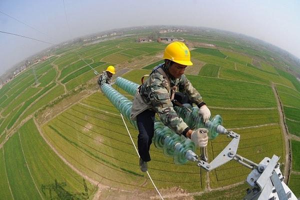 Çin'de yüksek voltajlı elektrik kablolarının montajını yapanlar