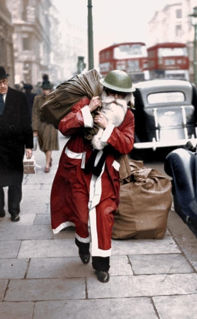 5. Father Christmas wearing a tin helmet walks along Regent Street, London, with a bag full of presents - from Life Magazine, December 23, 1940.