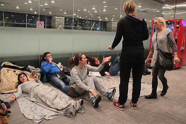 Uçuşları iptal edilen yolcular geceyi terminaldeki banklarda ve yerlerde uyuyarak geçirdi