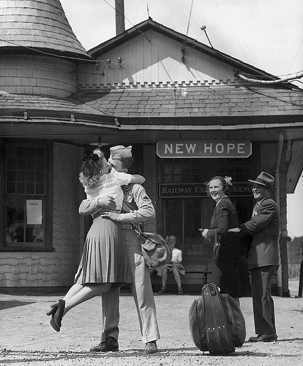 14. Connecticut'ta bir tren istasyonunda üniformalı bir Amerikan askerini romantik bir şekilde öpen genç kadın, 1945.