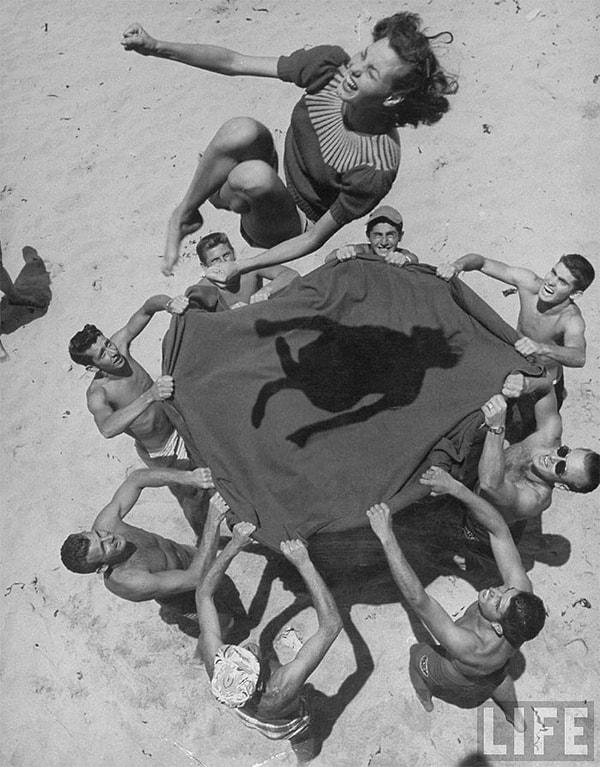 15. Norma Baker'ı (Marilyn Monroe) havaya fırlatmak için battaniye kullanan genç adamlar, 1948.