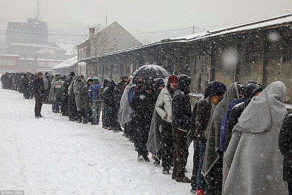 Göçmenler Belgrad'da terk edilmiş bir deponun arkasında yemek sırasında bekliyorlar. Dondurucu soğuklar yüzünden ülke çapında büyük önlemler alındı.