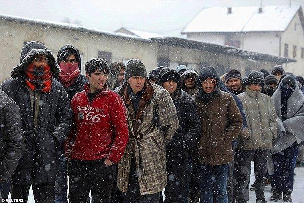 Diğer göçmenler de soğuktan korunabilmek için kat kat giyinmiş, sırada bekliyorlar.