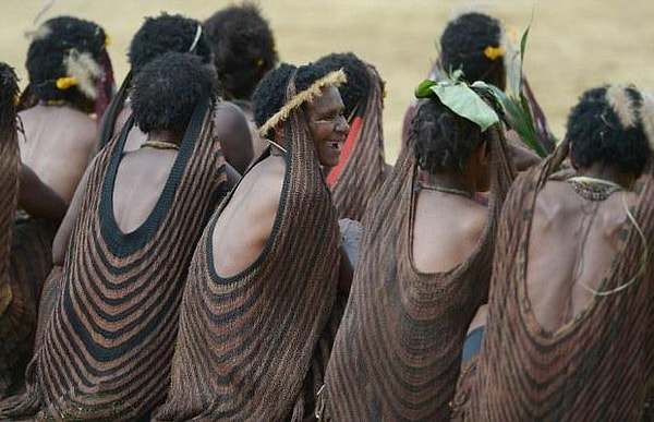 5. А так одеваются женщины племени. Они носят юбки и сплетенный мешок, который крепится на голове и называется нокен