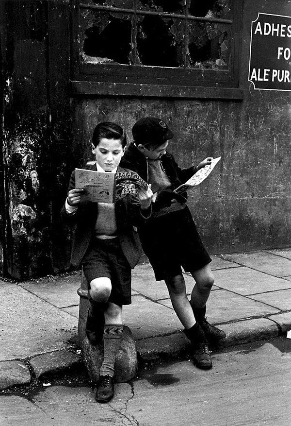 18. Sokakta çizgi romanlarına dalmış iki çocuk.