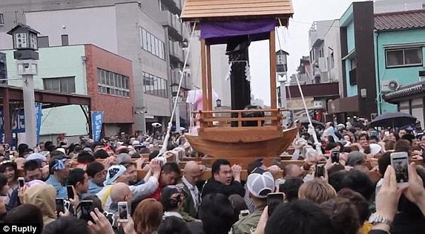Japonya'nın en büyük ahşap penisi olarak geçit sırasında erkekler tarafından taşınıyor.