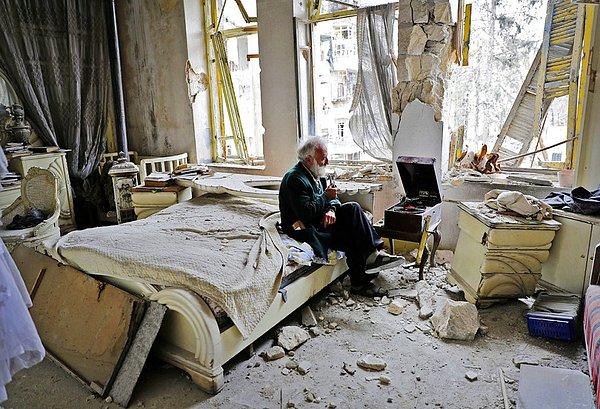8. Halep'in geriye yıkıntısı kalmış el-Şah mahallesinde piposunu içen ve plak dinleyen 70 yaşındaki Mohammed Mohiedin Anis.
