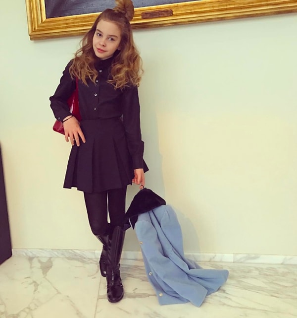 6. Она носит одежду из последних коллекций Dolce & Gabbana и Chanel, за спиной у нее красный портфель от одного из модных домов, а шикарные золотистые волосы собраны в модный полупучок.