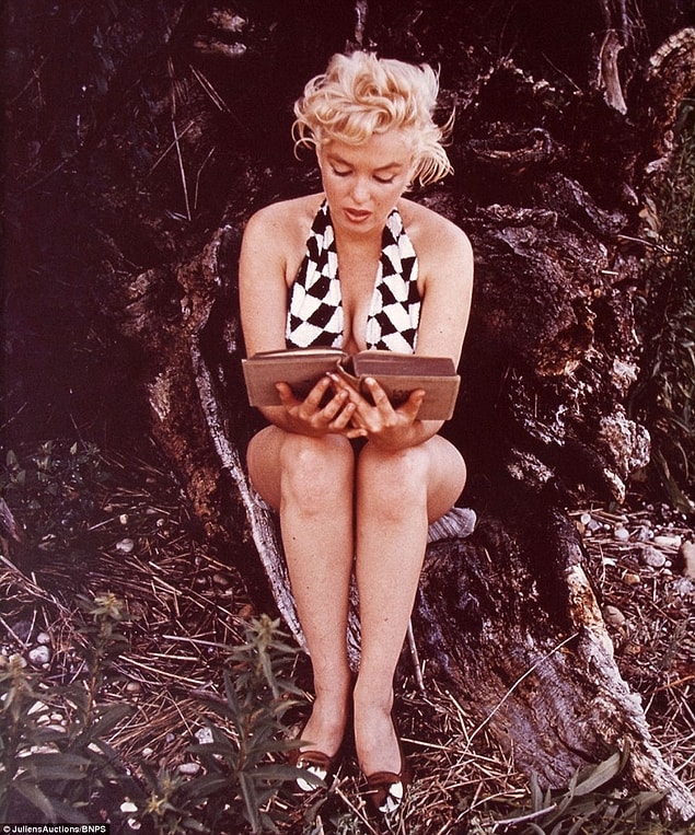 One unusual photo by Eve Arnold captures Monroe reading a book.