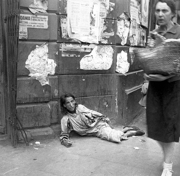 16. Varşova sokaklarında açlıktan ölmeye terk edilmiş, kaldırımda yatan bir kadın, Polonya, 1941.