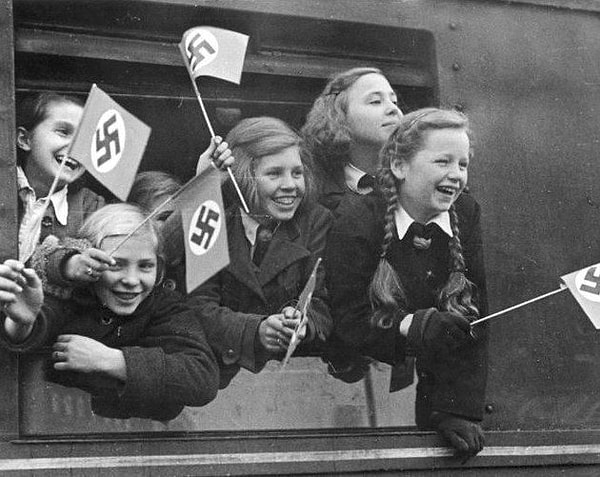 1. Дети машут флагами перед тем, как покинуть Берлин. Примерно 1940-1945 года