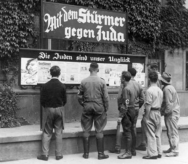 4. Группа мужчин читает доску с пропагандой, на которой написано "Евреи — наше несчастье", город Вормс. 1933