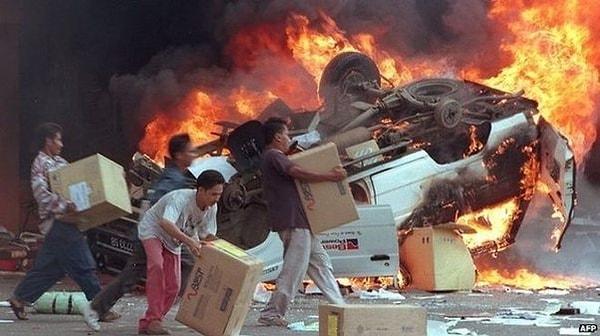 2. 1998'de Endonezya'da patlak veren ayaklanmalar esnasında Çinli dükkan sahiplerinin dükkanlarını yağmalayan insanlar.