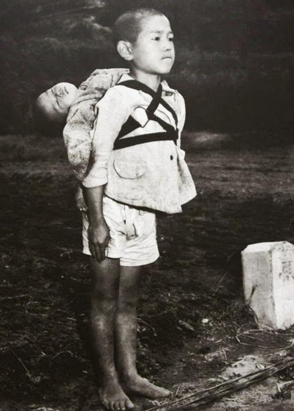 11. 1945'te ABD bombalamaları sonrası, muhtemelen kardeşinin cesedini sırtında taşıyan Japon çocuk.