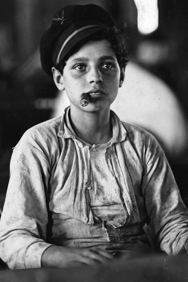 5. Left: A young boy smokes a cigar while he waits for work at a cigar manufacturer in Tampa, Florida, in 1909. Right: A young girl grasps a handful of shrimp while working at a shrimping dock during the 1900s.