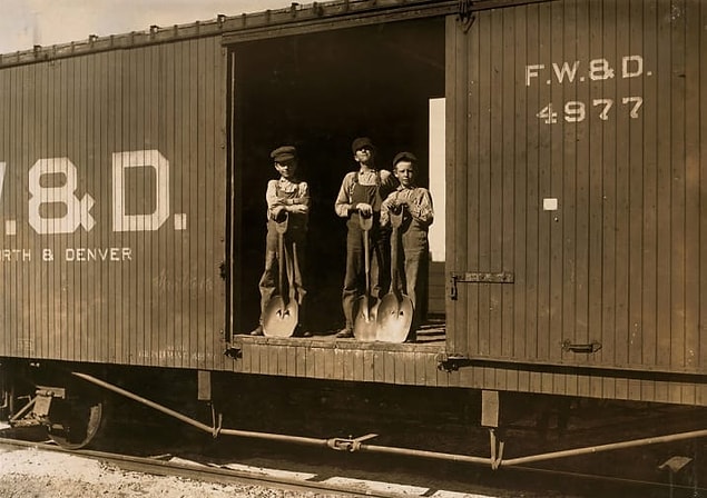 8. Three young boys wait for a shipment of zinc ore to shovel at a mine near Aurora, Missouri, circa 1910.