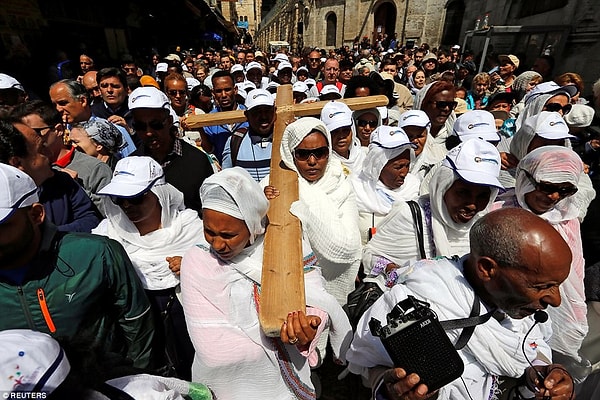 Верующие Иерусалима проносят деревянный крест по улицам города.