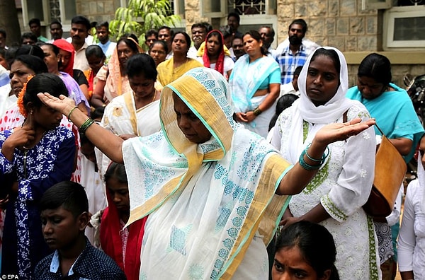 Дюжины людей собрались у изображения Христа, чтобы помолиться и вспомнить его великую жертву.