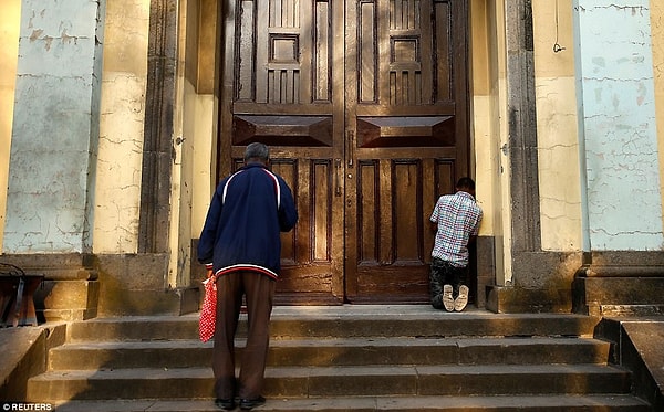 Те, кто не может войти в церковь, молятся на ступеньках храма в воспоминание о страданиях Христа.