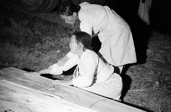 9. Одна кореянка пытается успокоить другую, пока та плачет над гробом возлюбленного (1952 год)