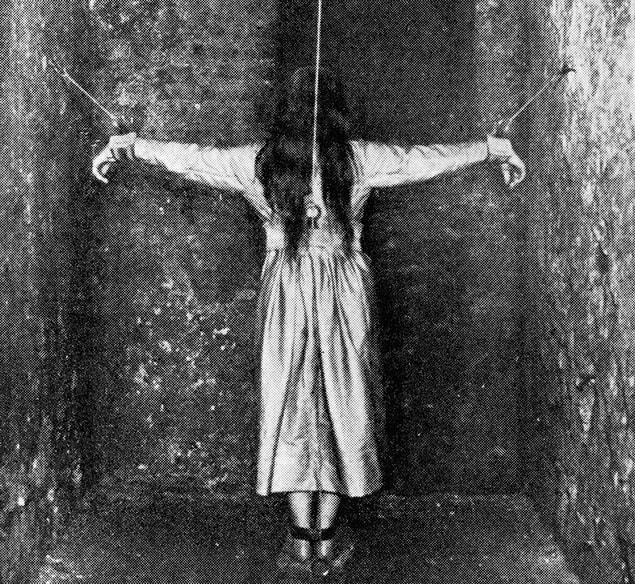 14. A patient undergoing treatment for mental illness in Germany by being forced into a crucifixion pose, 1890.