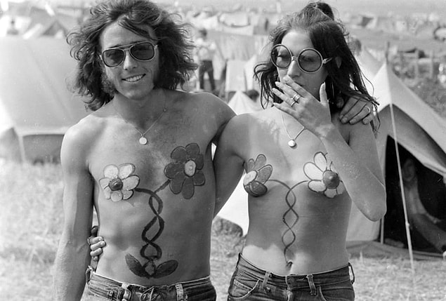 6. A couple with matching flower body paint walks together during the Isle of Wight Festival in the UK in 1970.