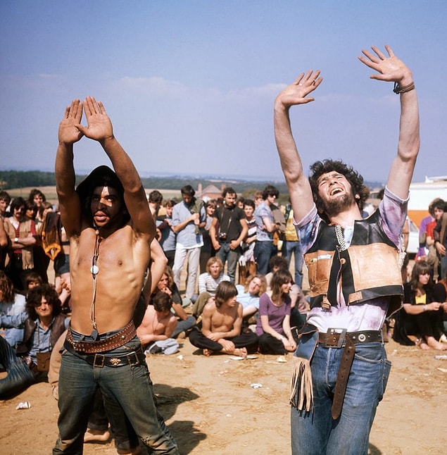 7. A group of hippies watch on as several others dance during the Isle of Wight Festival in 1969.