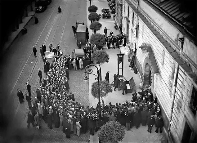 39. People waiting in the line to watch the last execution by guillotine. | 1939