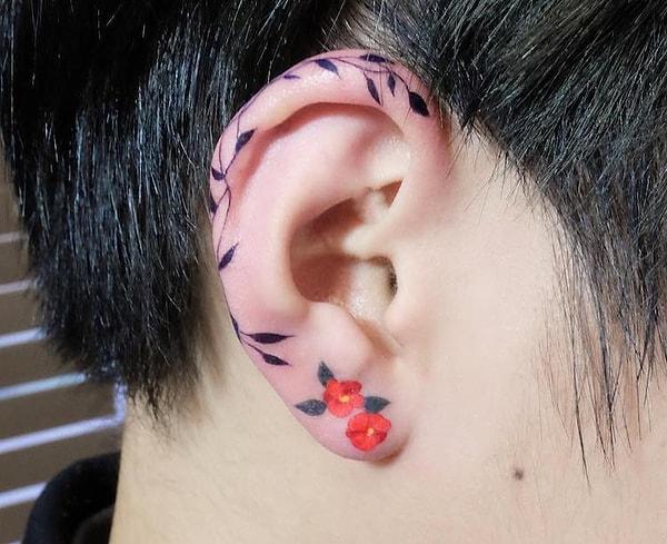 1. Koreli dövme sanatçısı Zihee'nin, kulak kıkırdağını saran bir asma ve küpe gibi duran iki çiçekten oluşan eseri.