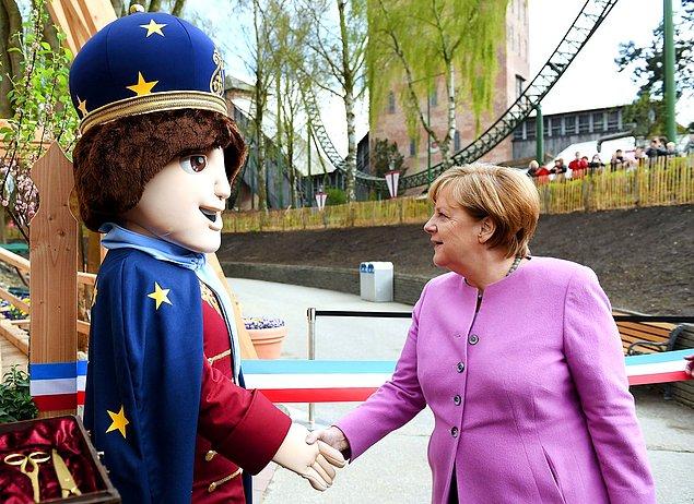 8. Seçim kampanyaları sırasında Angela Merkel bir maskot ile el sıkışıyor.