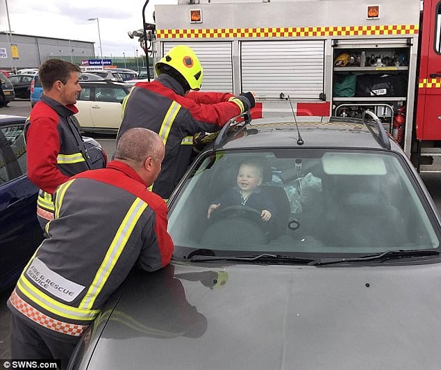 A laughing toddler in Cornwall was rescued by hero firefighters after they battled to free him from a locked car while he watched from the driver's seat.